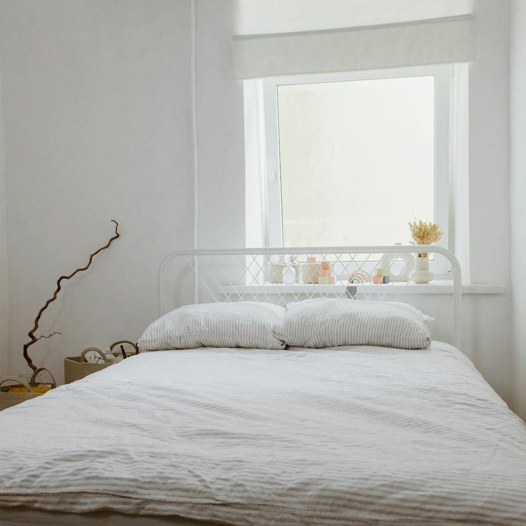 Modern bedroom interior with made bed and lamps